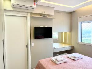 a room with a table and a tv and a kitchen at Apartamento Maravilhoso Maranata Vila Industrial in São José dos Campos +20 photos