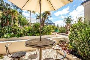 a table and two chairs with an umbrella at Onetangi Beach Apartments in Onetangi