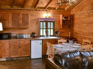 a kitchen with a table and a white refrigerator at The Sunset Cabin in Beccles