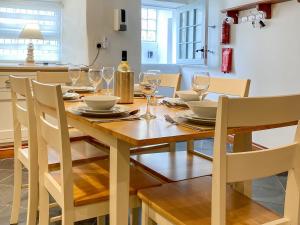 a dining room with a wooden table with wine glasses at Mill Head Cottage in Ilfracombe