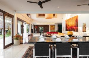 a dining room with a table and a couch at Villa Manis Canggu in Canggu