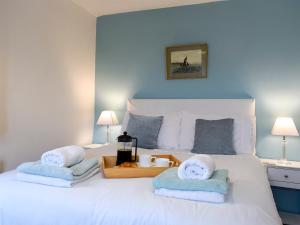 a bedroom with a white bed with towels on it at Mallards Nest in Skipton
