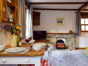 a living room with a table and a fireplace at Mallards Nest in Skipton