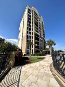 a tall building with a fence in front of it at Lovely 22 In Sienna Overlooking The Gulf in Gulfport