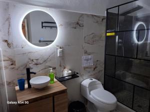 bagno con servizi igienici, lavandino e specchio di Casa Breizh ad Acapulco