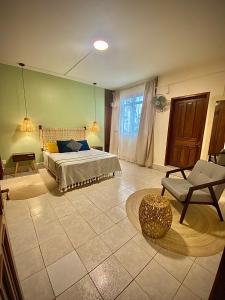 1 dormitorio con 1 cama y 1 silla en Hostal Central Oaxaca en Oaxaca de Juárez