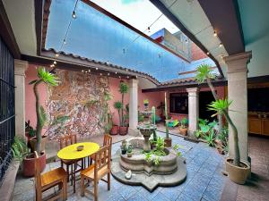 une terrasse avec une table, des chaises et des plantes dans l'établissement Hostal Central Oaxaca, à Oaxaca