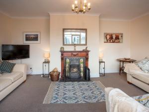 a living room with a fireplace and a tv at Todburn East in Longhorsley