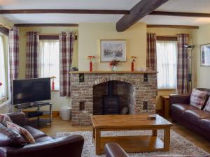 a living room with a fireplace and a tv at Captains Cottage - E3643 in Whitby