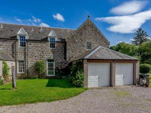 a large stone house with two garages at Skene House Court in Dunecht