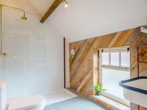 a bathroom with a toilet and a window at Turnip Cottage in Newsham