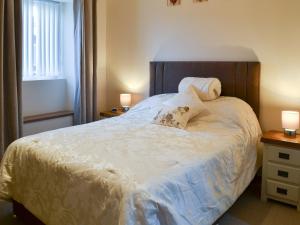 a bedroom with a large white bed with two lamps at Heckley Stable Cottage in Alnwick