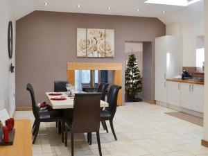a dining room with a table and chairs and a christmas tree at Heckley Stable Cottage in Alnwick