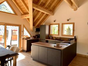 a large kitchen with wooden ceilings and a table at Chalet 8 pers 4* à Valloire - Centre, Terrasse, Proximité Télécabine et Commerces - FR-1-263-524 in Valloire