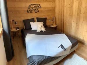 un osito de peluche blanco sentado en una cama en una habitación en Chalet Valloire, 5 pièces, 8 personnes - FR-1-263-524 en Valloire