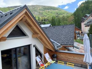 a house with a roof with chairs and a table at Chalet Valloire, 5 pièces, 8 personnes - FR-1-263-524 in Valloire