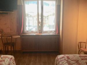 a bedroom with a window and a radiator and a table at Appartement Les Gets, 1 pièce, 3 personnes - FR-1-671-129 in Les Gets