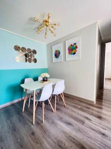 a dining room with a white table and chairs at Apartamento General Mackenna B&E in Santiago