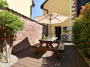 a picnic table with an umbrella on a patio at Charmant F2 avec jardin privatif, climatisation, et parking - Au cœur du vignoble alsacien ! - FR-1-744-1 in Bergholtz