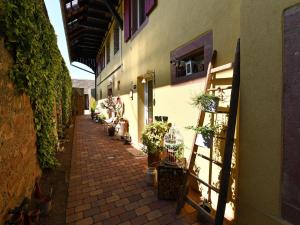 an alley with potted plants on the side of a building at Gîte alsacien 75m² avec 2 chambres, climatisation, jardin privé, proche Colmar et Mulhouse - FR-1-744-2 in Bergholtz