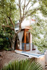 una casa con un balcón azul y un árbol en Hostal Tunich Naj & Hotel, en Valladolid