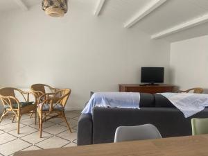 a living room with a couch and a table and chairs at Maison rénovée 2 ch, terrasse, proche plage et centre, parking, équipements complets, animaux ok - FR-1-22-356 in La Tranche-sur-Mer