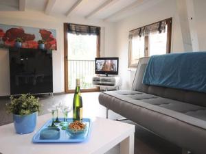 a living room with a couch and a table with a bottle of wine at Gîte Eguisheim, 3 pièces, 4 personnes - FR-1-744-15 in Eguisheim