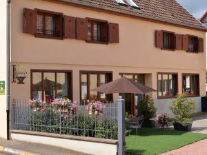 una casa con una recinzione con fiori e un ombrello di Gîte Eguisheim, 3 pièces, 4 personnes - FR-1-744-15 a Eguisheim