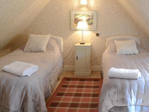 a attic room with two beds and a lamp at Tressady Coach House in West Langwell