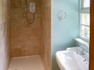 ein Bad mit einer Dusche und einem Waschbecken in der Unterkunft Tressady Coach House in West Langwell