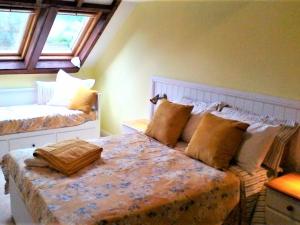1 dormitorio con 2 camas y almohadas en Stable Lodge, en Gattonside