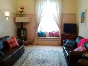 a living room with a couch and a window at Stable Lodge in Gattonside