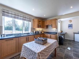 a kitchen with a table with a basket on it at Old Alton Hall Farmhouse in Tattingstone