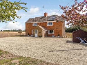 a large brick house with a gravel driveway at Old Alton Hall Farmhouse in Tattingstone