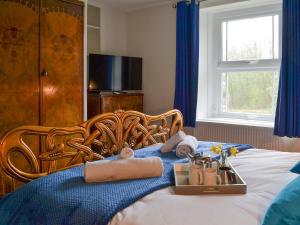 Una habitación de hotel con una cama con toallas y una bandeja de artículos en Cranford House, en Woolfardisworthy