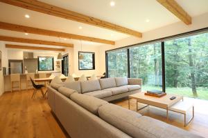 a living room with a couch and a table at SEVEN TREES BY AOKIKO in Omachi