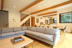 a living room with a couch and a table at SEVEN TREES BY AOKIKO in Omachi