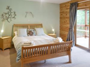um quarto com uma cama de madeira e uma janela em Gilnockie em Kippford