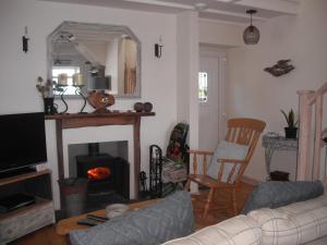 a living room with a couch and a fireplace at Gull Cottage in Lendalfoot