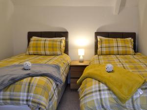 zwei Betten mit Teddybären darauf in einem Schlafzimmer in der Unterkunft Golwg Y Mor in Burry Port