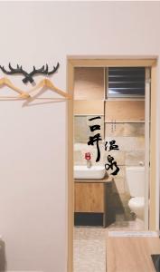 La salle de bains est pourvue d'un lavabo et de toilettes. dans l'établissement 一口井溫泉 One Well Hot Spring, à Jiaoxi