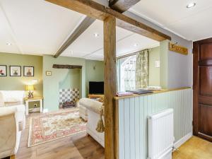 a living room with green walls and wooden beams at Duck Island Cottage in Ringwood