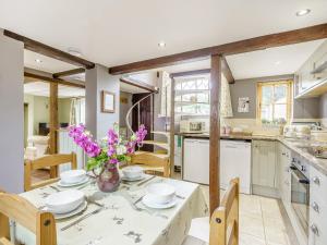 a kitchen with a table with flowers on it at Duck Island Cottage in Ringwood