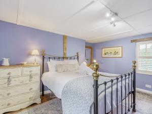a bedroom with a bed and a dresser at Duck Island Cottage in Ringwood