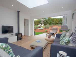 a living room with a blue couch and a tv at Haldon View in Lympstone