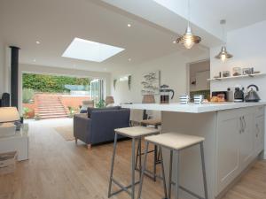 a kitchen and living room with a counter and stools at Haldon View in Lympstone