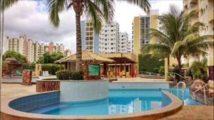 une piscine bordée de palmiers dans une ville dans l'établissement 1403 AP 2 Quartos , banheira de hidro privativa, bebidas liberadas nas piscinas , internet no ap, proximo ao shopping singapura, à Caldas Novas