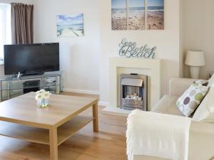 a living room with a tv and a coffee table at Seagull Cottage in Portreath