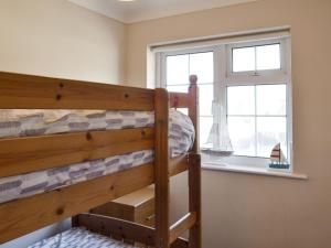 a bedroom with a bunk bed and a window at Seagull Cottage in Portreath