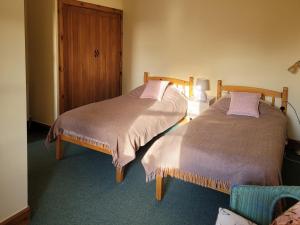 two beds sitting next to each other in a room at The Hen Hoose in Blainslie